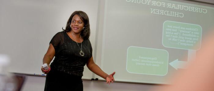 Woman giving presentation to a class.
