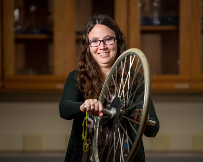 Photo of Robynne Lock holding a bicycle tired used for an experiment.