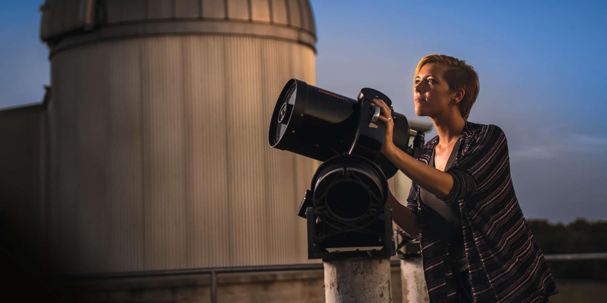 Image of a woman looking at a telescope.