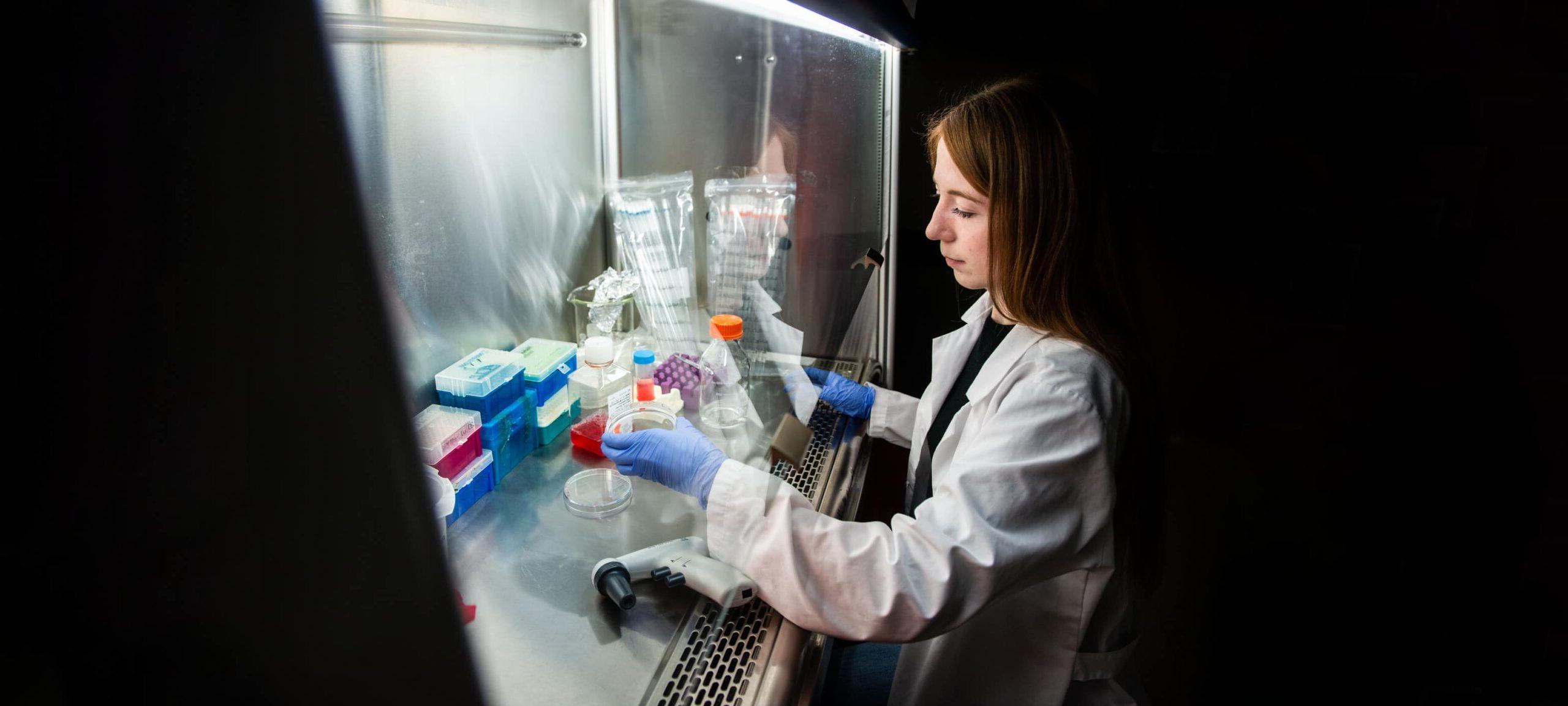 一个女学生在实验室看药瓶.