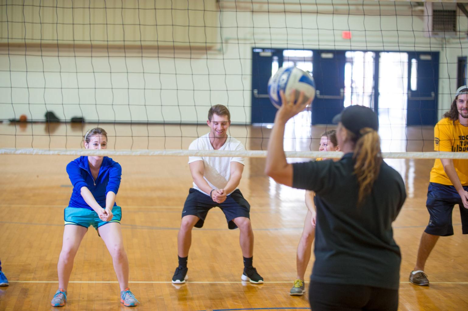 Student learning volleyball inside the Gym in the Commerce campus.